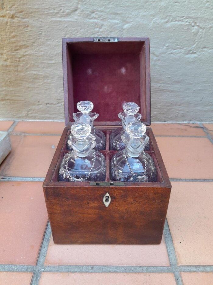 An 18th / Early 19th Century Georgian Mahogany Tantalus With Four Cut Glass Decanters And Three Georgian London Silver Wine Labels